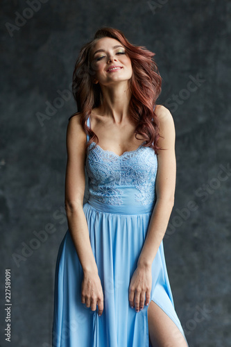 Beautiful girl with make up and hair in long blue dress