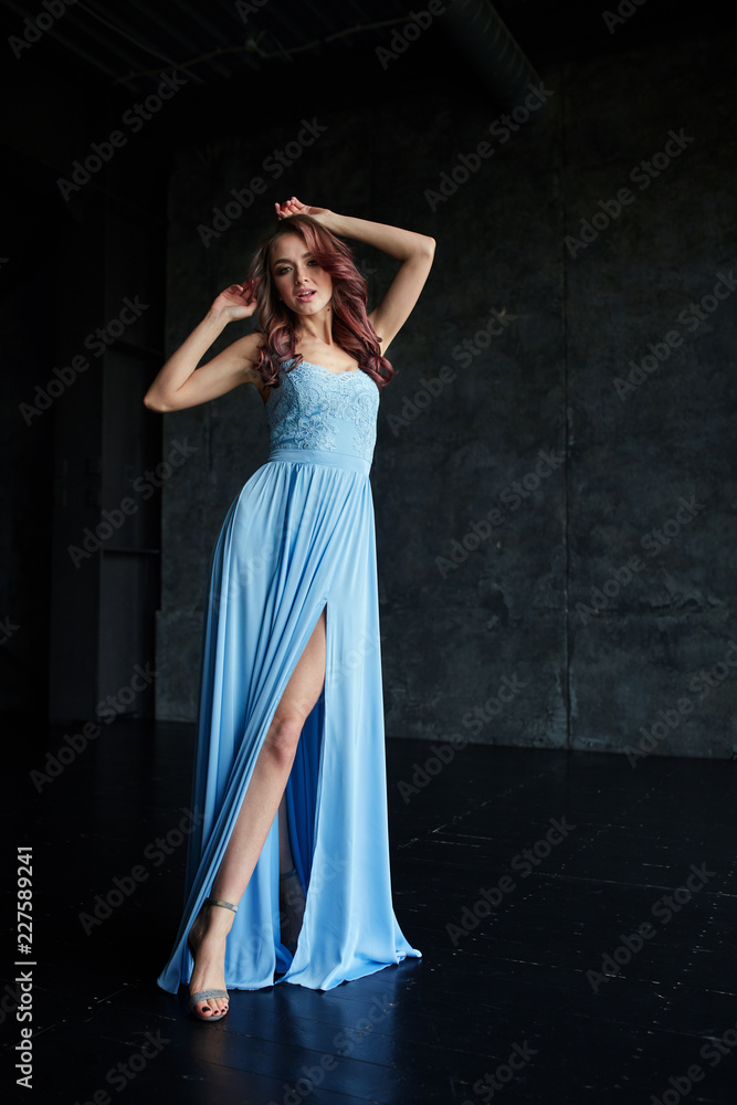 Beautiful girl with make up and hair in long blue dress