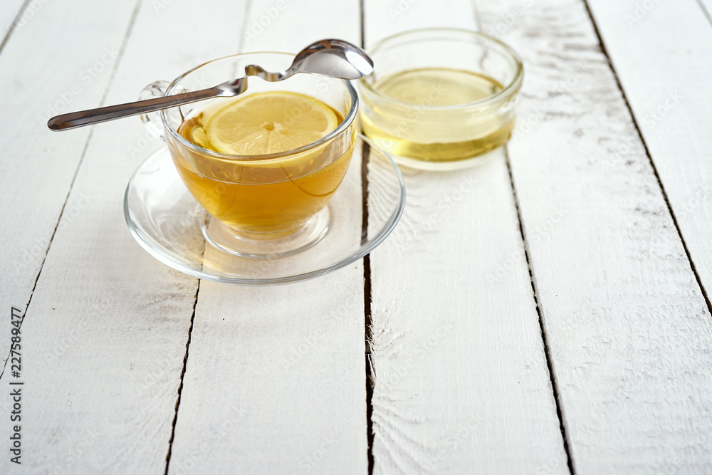 delicious hot tea with lemon and honey on an old white wooden table delicious hot tea with lemon and honey on an old white wooden table