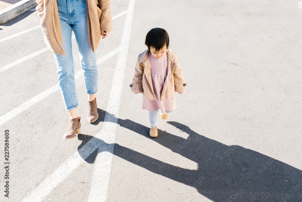 Baby and mom walking across street in city Baby and mom walking across street in city