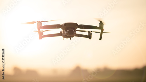 Drone like Mavic 2 Pro flying during sunset. photo
