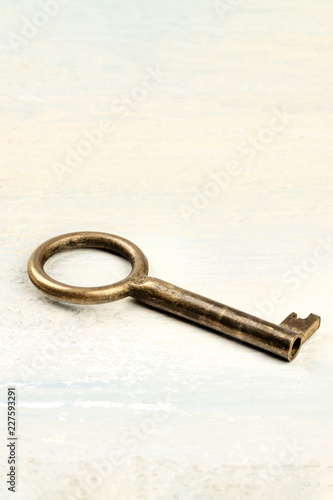 A photo of a vintage key on a light background with copyspace