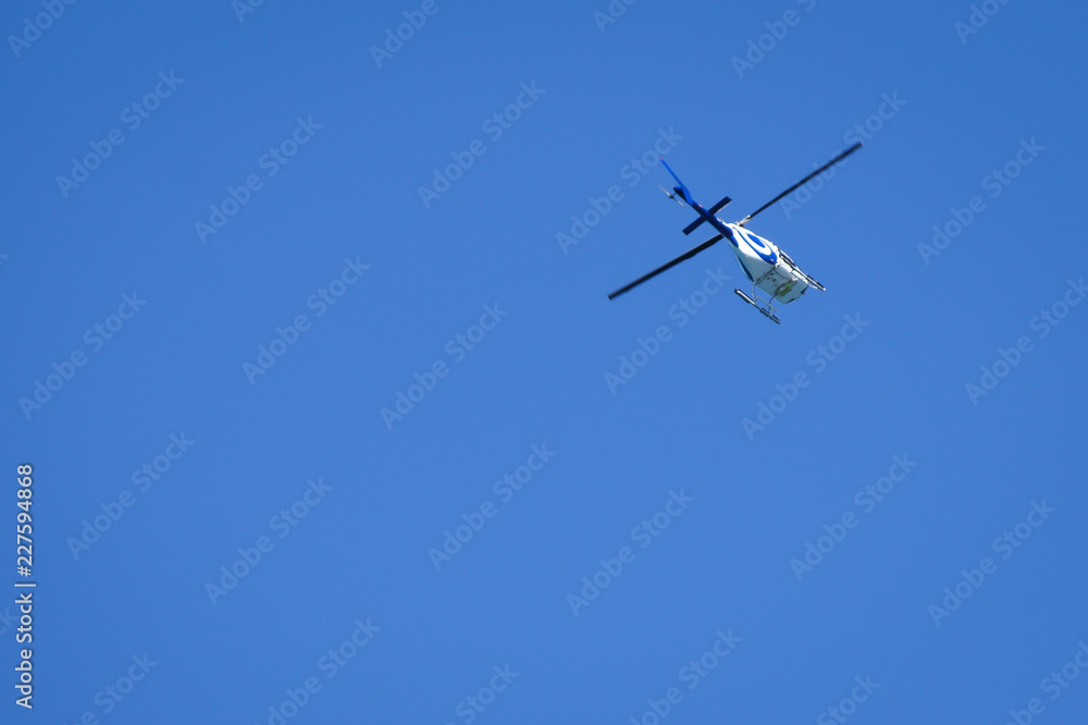 Helicopter in flight from below against blue sky. Add your own text. Helicopter in flight from below against blue sky. Add your own text.