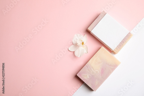 Flat lay composition with handmade soap bars on color background. Space for text