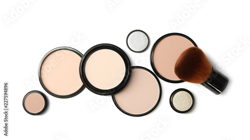 Flat lay composition with different makeup face powders on white background