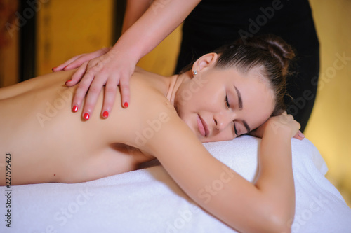 Masseur applying beauty massage on a female client Lateral view in the spa