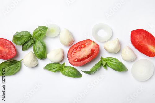 Fresh green basil leaves, tomatoes and mozzarella on white background, top view