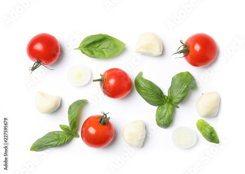 Fresh green basil leaves, cherry tomatoes and mozzarella on white background, top view