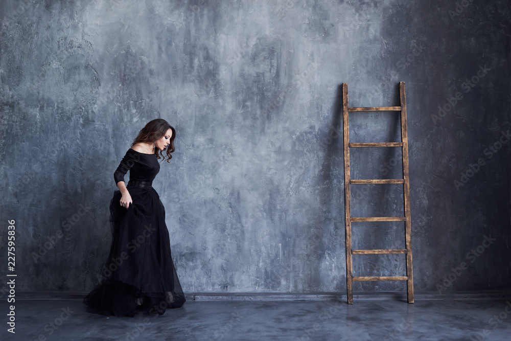 Beautiful girl with makeup and hairdo in a black dress Beautiful girl with makeup and hairdo in a black dress
