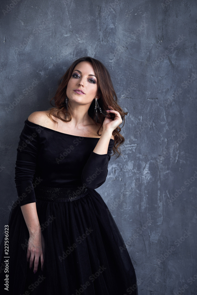 Beautiful girl with makeup and hairdo in a black dress Beautiful girl with makeup and hairdo in a black dress