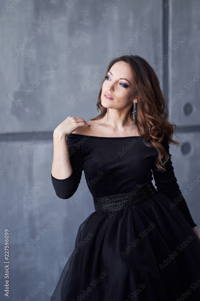 Beautiful girl with makeup and hairdo in a black dress Beautiful girl with makeup and hairdo in a black dress