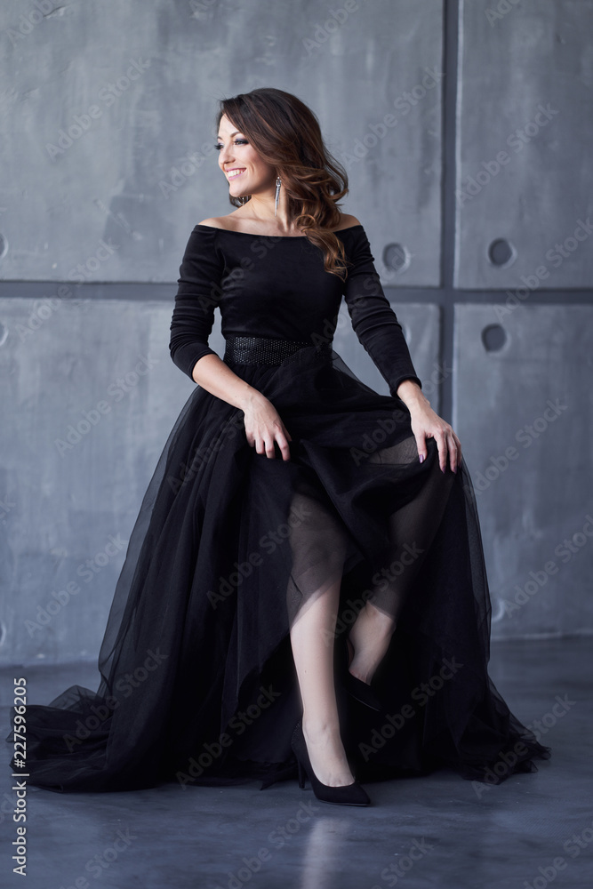 Beautiful girl with makeup and hairdo in a black dress Beautiful girl with makeup and hairdo in a black dress