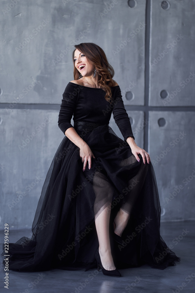 Beautiful girl with makeup and hairdo in a black dress Beautiful girl with makeup and hairdo in a black dress