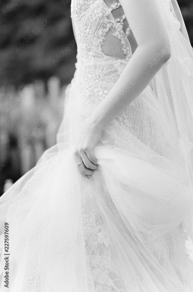 A bride delicately holds her wedding gown A bride delicately holds her wedding gown