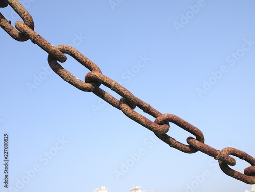 Rusty metal chain with blue sky background