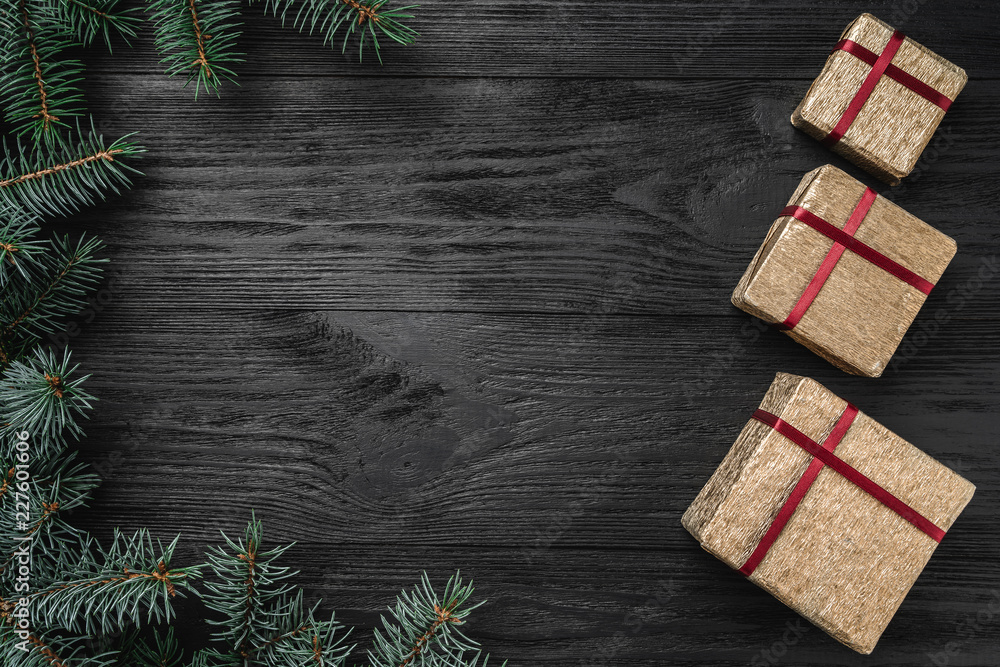 Wallpaper of winter holidays on black background. Side fir branches. Gold Gifts. Space for text. Top view Wallpaper of winter holidays on black background. Side fir branches. Gold Gifts. Space for text. Top view