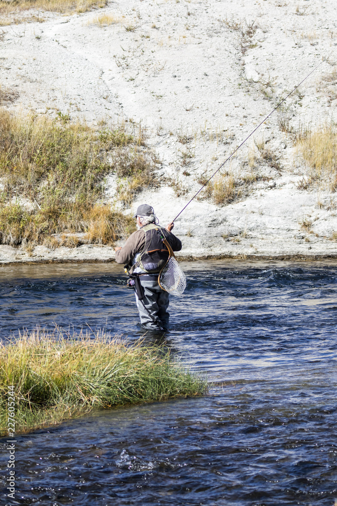 A man fishing for trout in the Firehole River in Yellowstone National Park.