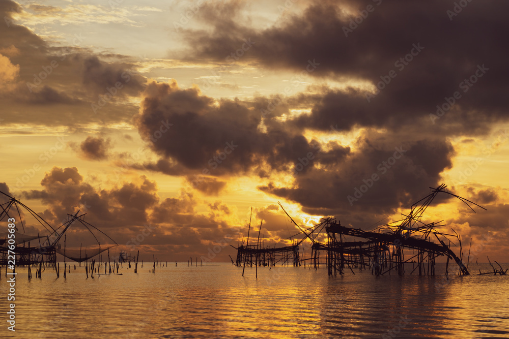 Traditional fishing nets over cloudy sunrise at Phatthalung, Thailand.