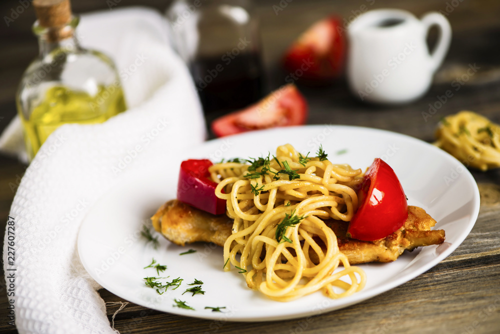 pasta and fried meat with spices and vegetables on a wooden board pasta and fried meat with spices and vegetables on a wooden board
