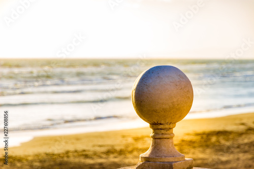 Follonica seaside and stone sphere  at sunsetn in late winter, Italy photo