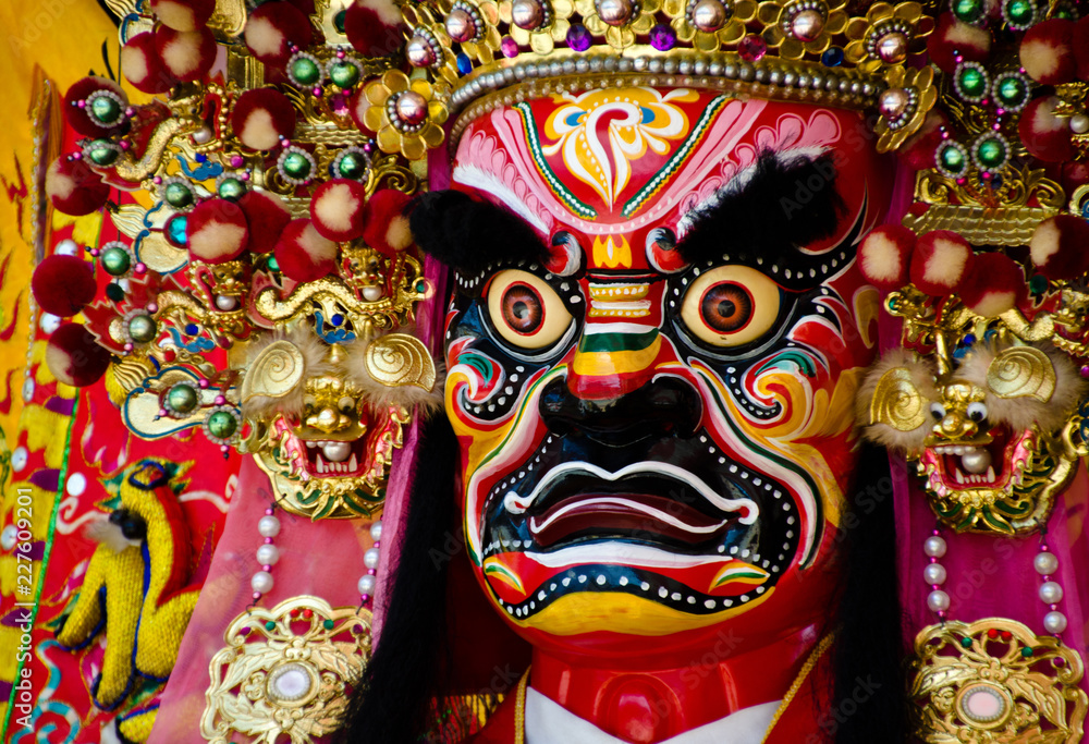 Colorful face of a Chinese deity. The face of the diety and the head ornament are refined pieces of artwork. There are red, pink, yellow, white, yellow, blue and green colors on it. Colorful face of a Chinese deity. The face of the diety and the head ornament are refined pieces of artwork. There are red, pink, yellow, white, yellow, blue and green colors on it.