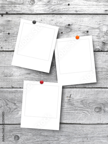 Three blank square instant photo frames on white wooden background