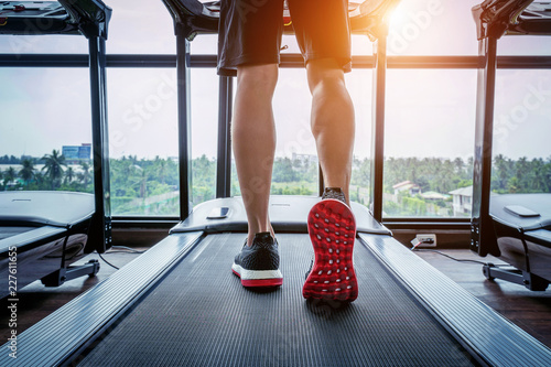Male feet in sneakers running on the treadmill at the gym. Exercise concept.