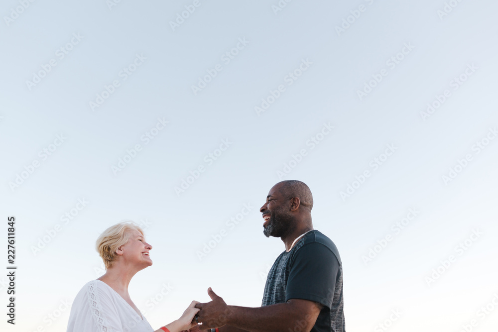 Fun middle aged couple enjoying quality time on the beach at sun Fun middle aged couple enjoying quality time on the beach at sun