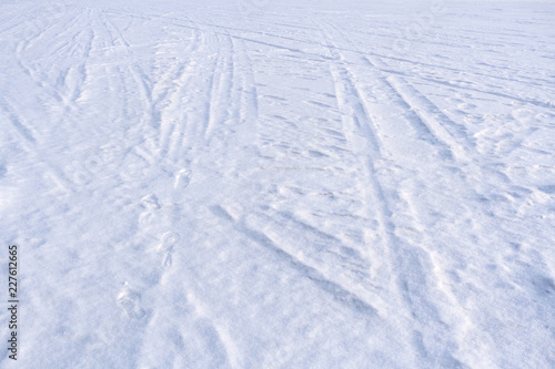 Traces of sledge runners and ski on white freshly fallen snow.