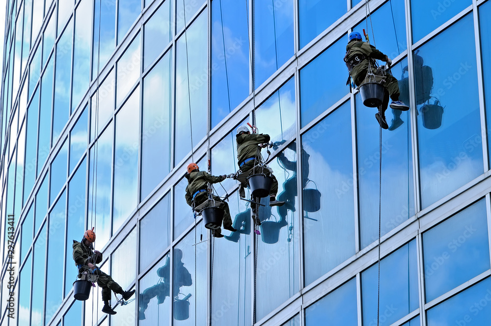 Industrial climbers wash windows of skyscraper Industrial climbers wash windows of skyscraper