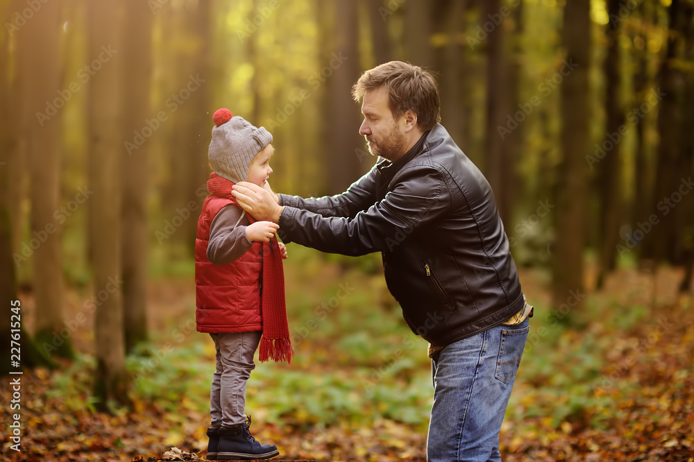 Fototapeta premium Little boy with his father during stroll in the forest