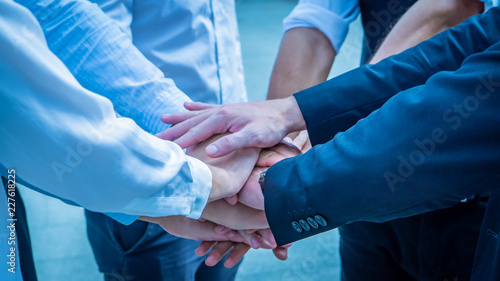 Closeup on hands. Colleague putting their hands on top of each other symbolizing unity and teamwork while doing activity outdoor. People joining hand together as a business goal achievement.