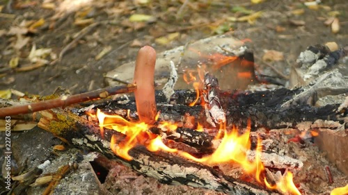 Wallpaper Mural Fragrant sausage rotates over the fire in the open air. The concept of tourism and outdoor recreation. Happy family grills juicy sausages on the coals. Torontodigital.ca