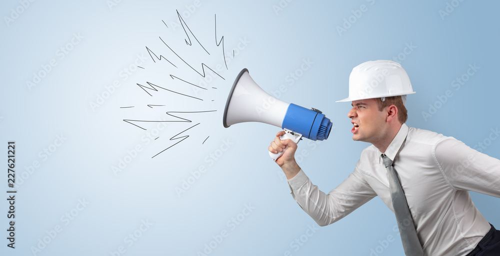 Young architect constructor yelling with megaphone and copyspace
Young architect constructor yelling with megaphone and copyspace