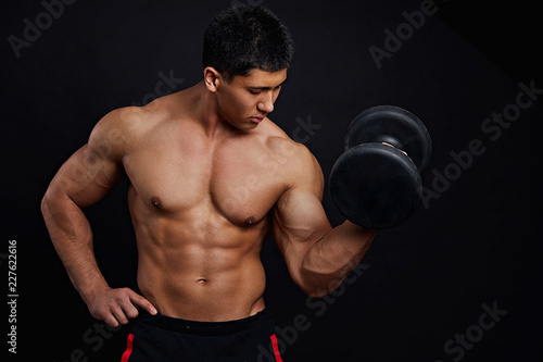 Fotografia naked to the waist athkete working out with dumbbell