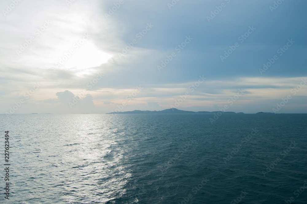  Far blue seascape with mountains on horizon. Thailand Islands at the sun set. Blue sky with clouds