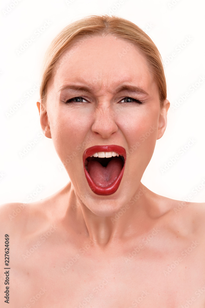 Beautiful blonde woman with pretty blue eyes and red lips. A scary female in pain holding her head and screaming in anger with an open mouth on her menstrual cycle period pain Beautiful blonde woman with pretty blue eyes and red lips. A scary female in pain holding her head and screaming in anger with an open mouth on her menstrual cycle period pain