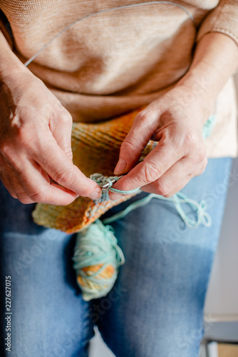 Woman Knitting a scarf. Hands holding threads. Colorfull Knitting