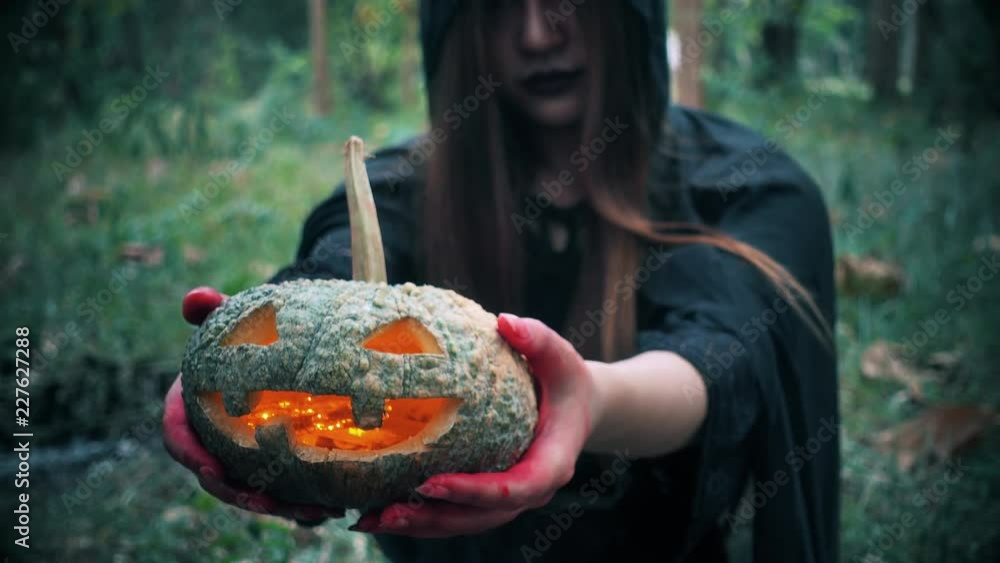 Woman ghost horror her have pumpkin on hand in forest, halloween day concept Woman ghost horror her have pumpkin on hand in forest, halloween day concept