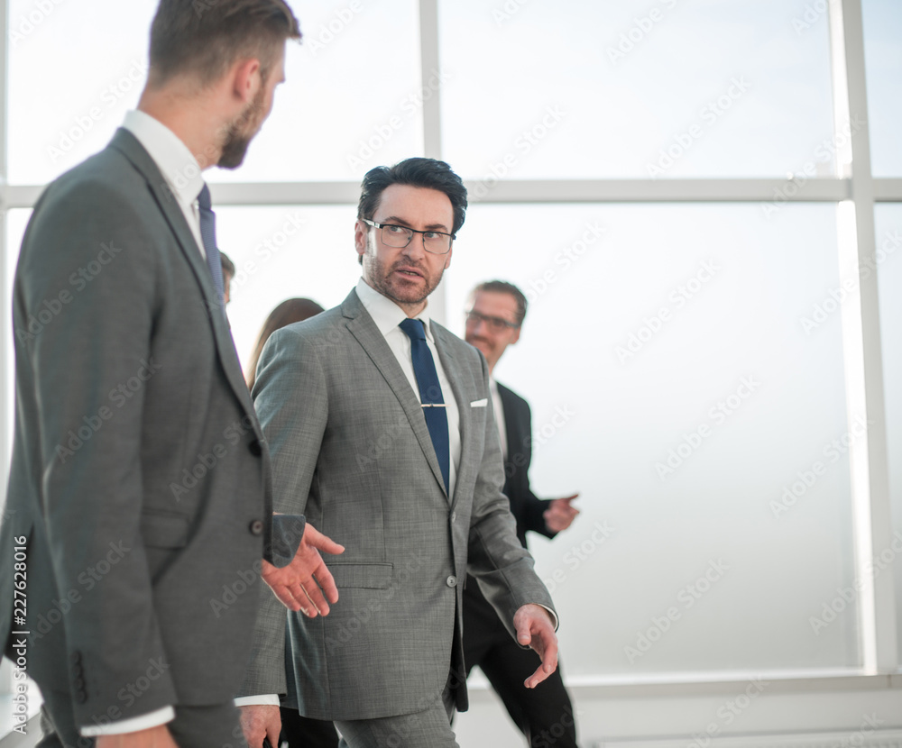 Two businesspeople walking in corridor talking Two businesspeople walking in corridor talking