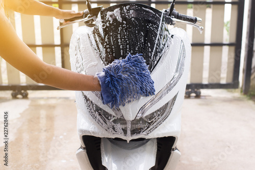 Car wash,Happy man cleaning motorcycle wash foam water at home