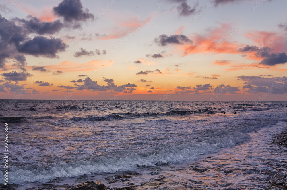 Sunset through the clouds over the sea.