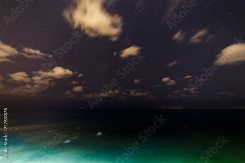 Clouds and stars over the night sea.