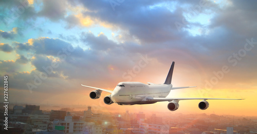 Big white airplane is flying over the clouds with colorful sky at sunset for Business trip with Commercial plane , Transportation, import-export and logistics, Travel concept