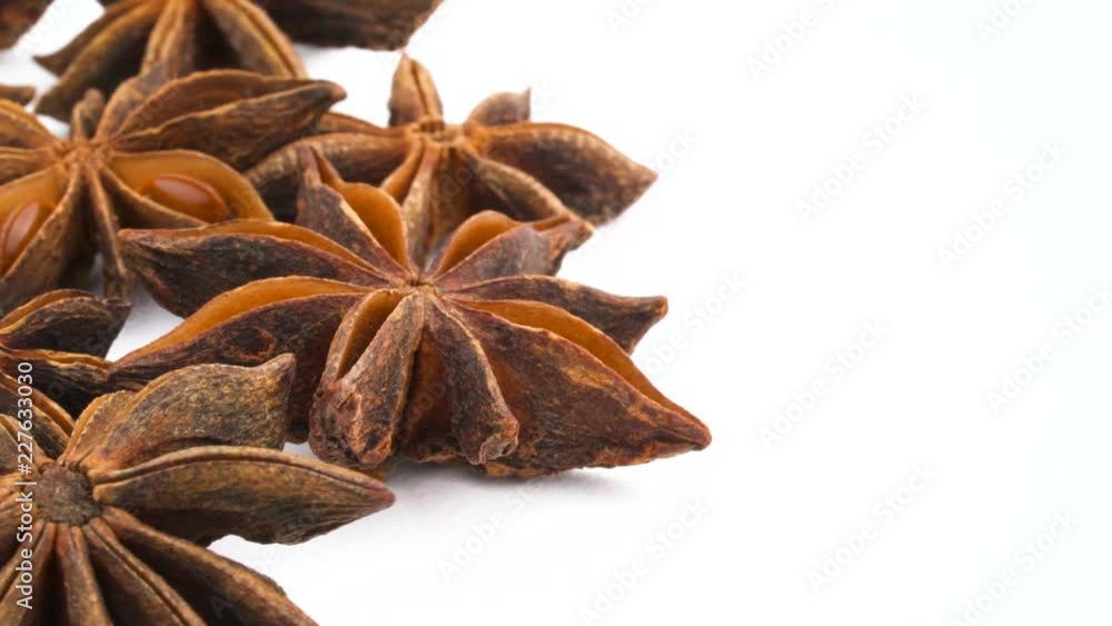 Vertical half frame of one star shaped star anise fruit. Slowly rotating on the turntable isolated on the white background. Close up. Macro. Copy space. Vertical half frame of one star shaped star anise fruit. Slowly rotating on the turntable isolated on the white background. Close up. Macro. Copy space.