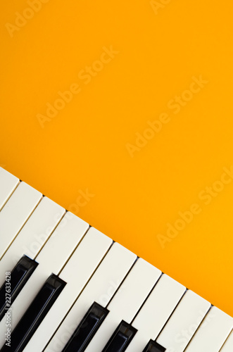 Vertical abstract orange background with the piano keys in the down-left corner