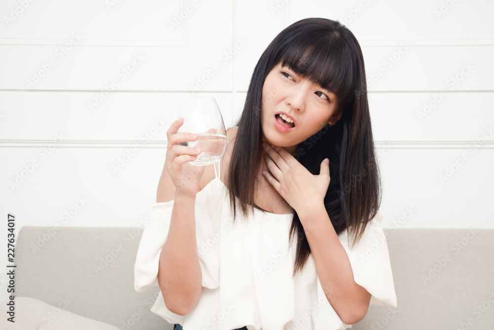 The asian woman cough and has a sore throat. Causes of sore throat include flu or allergy. The asian woman cough and has a sore throat. Causes of sore throat include flu or allergy.