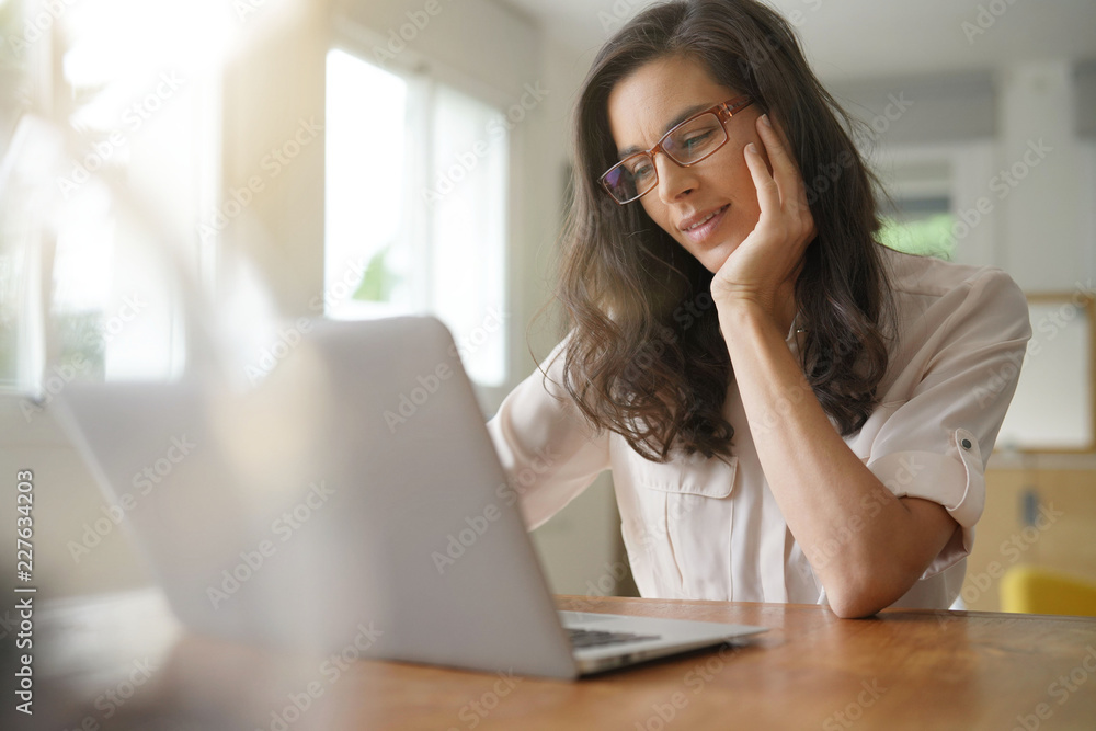 Beautiful dark-haired woman with glasses working on laptop Beautiful dark-haired woman with glasses working on laptop