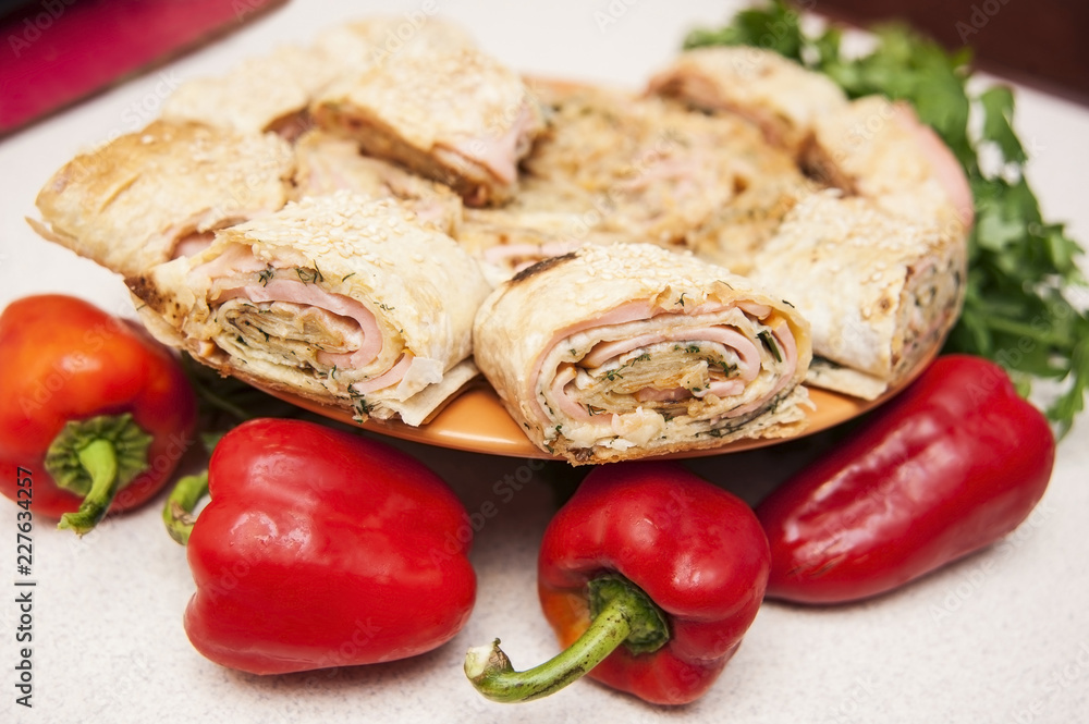 Shawarma with pita bread and sausage with cheese is on a plate along with red pepper and parsley. Shawarma is cooked at home Shawarma with pita bread and sausage with cheese is on a plate along with red pepper and parsley. Shawarma is cooked at home