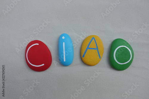 Ciao, italian greet word composed sith colored stones over white sand